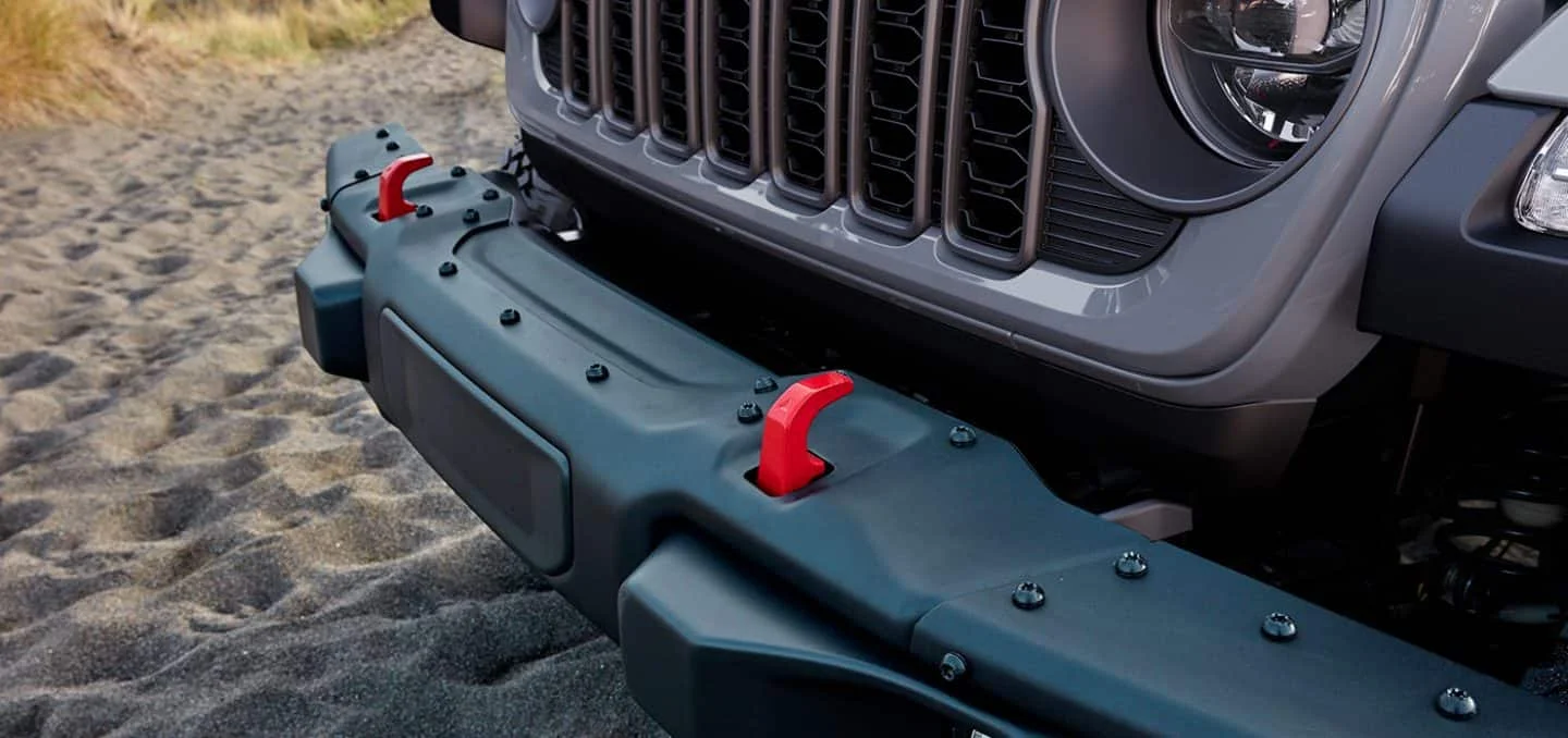Blue 2026 Jeep Gladiator Trail Rated model splashing through water on a rocky trail